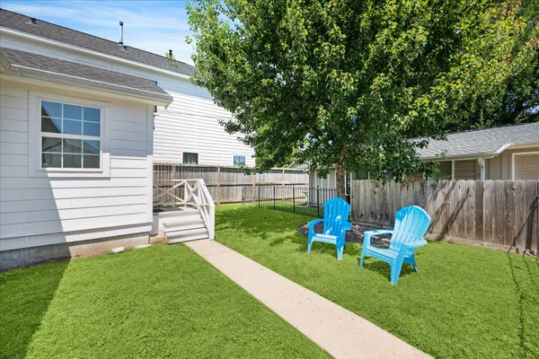 a view of a chair and table in backyard of the house