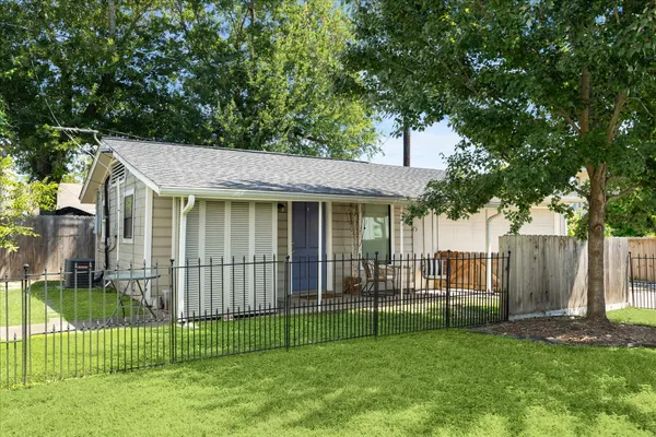 a view of a house with a backyard and a tree