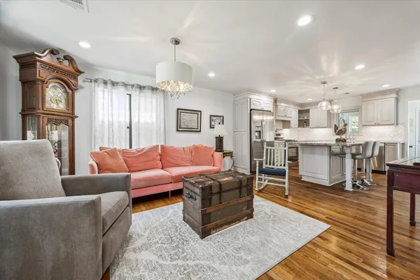 a living room with stainless steel appliances lots of wooden furniture