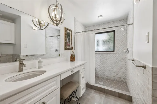 a bathroom with a sink a mirror and a shower