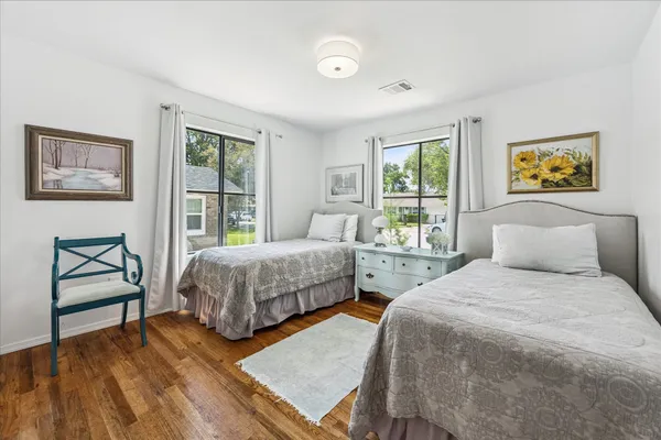a bedroom with two beds and a painting on the wall