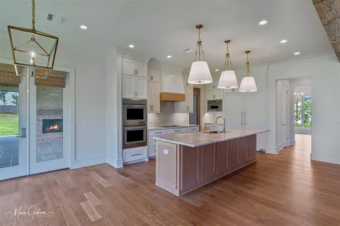 an open kitchen with wooden floor and large cabinets