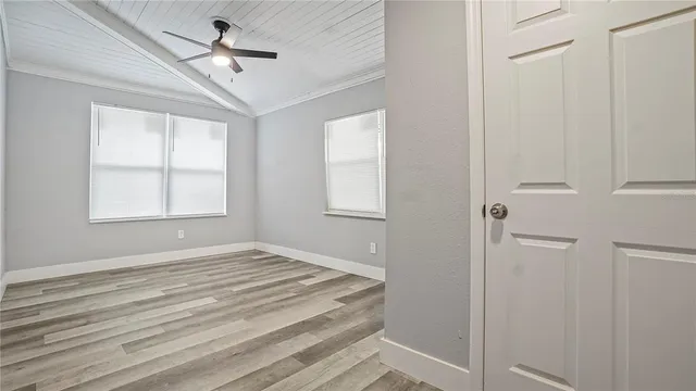 a view of empty room with window and ceiling fan