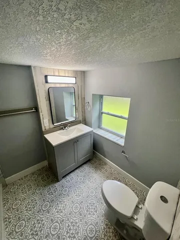 a bathroom with a toilet sink and mirror
