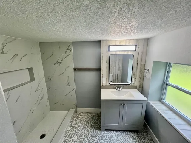 a bathroom with a double vanity sink mirror and tub
