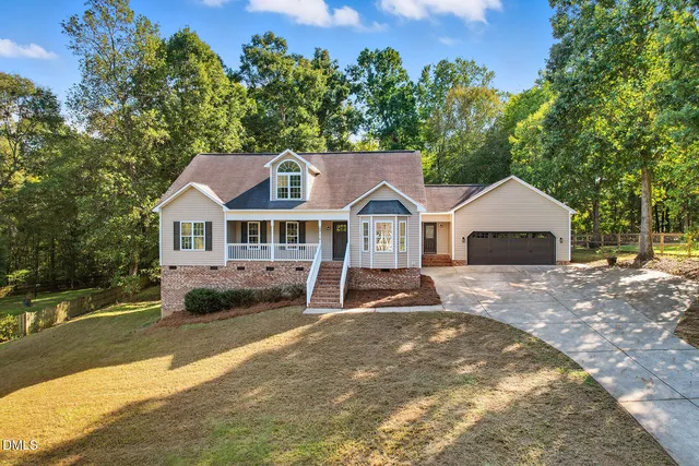 a front view of a house with a yard and trees