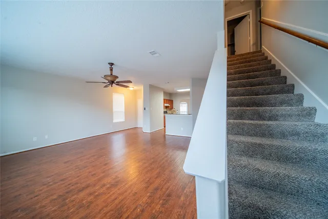 an empty room with a window and a ceiling fan