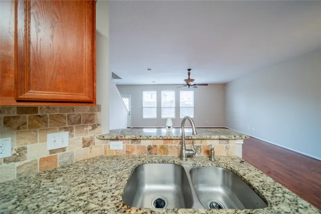 an empty room with a chandelier fan and a fireplace