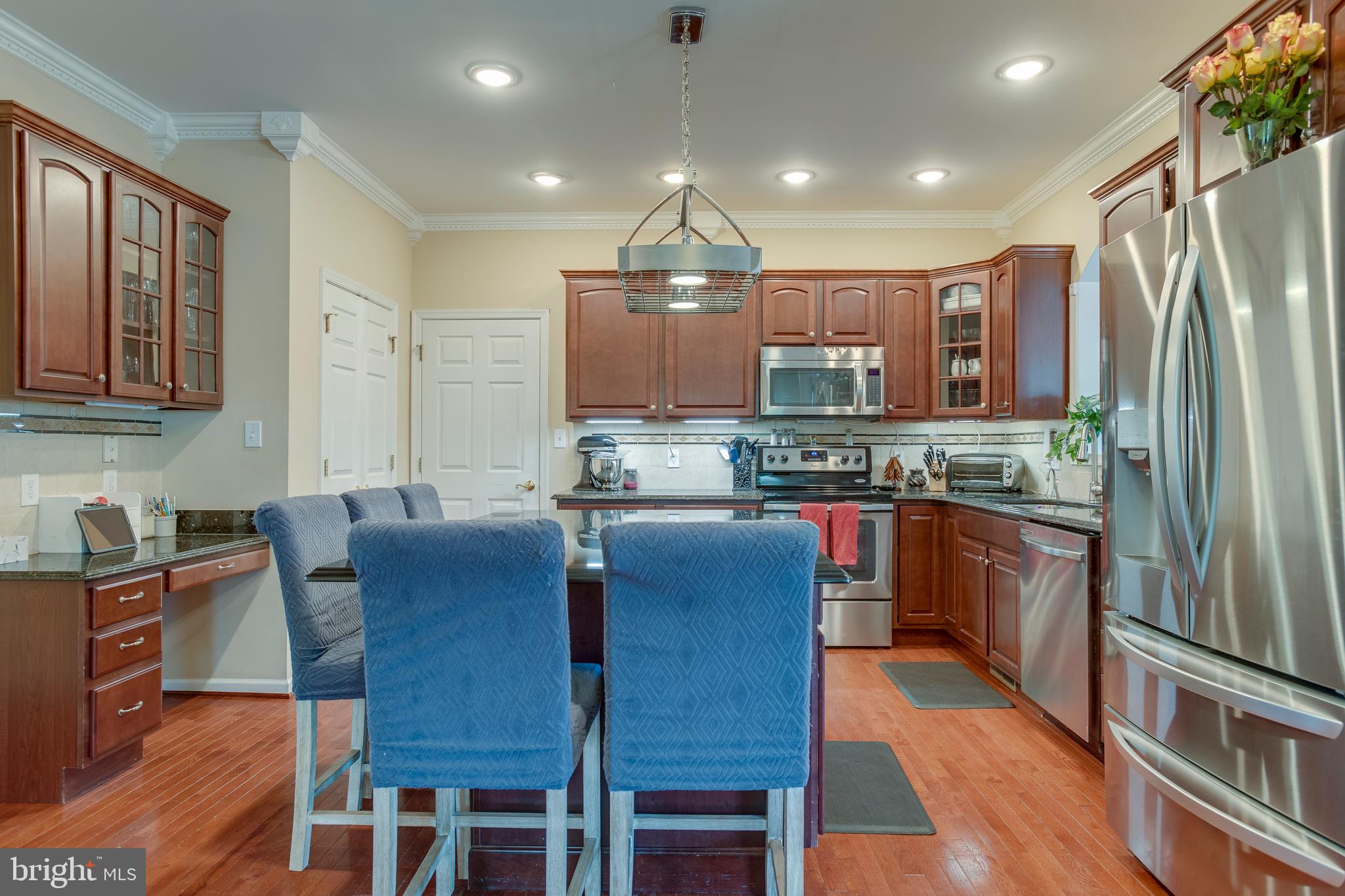 101 Saylers Creek Road Locust Grove, VA 22508 - Photo 10 of 89 a kitchen with stainless steel appliances granite countertop a refrigerator a stove top oven a sink dishwasher and dining table with wooden floor