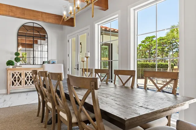 a kitchen with a dining table chairs and white kitchen