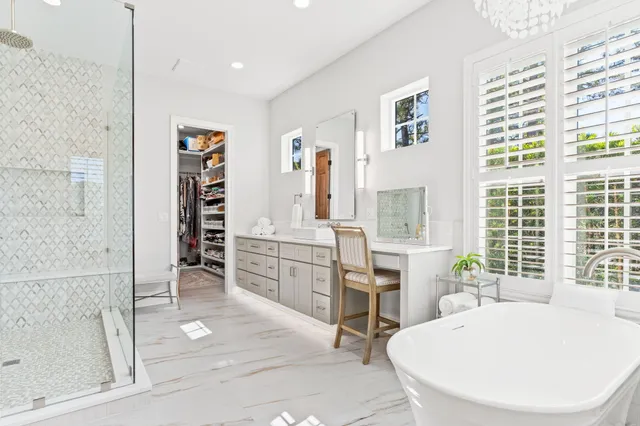 a spacious bathroom with double vanity a window a double vanity and a bathtub
