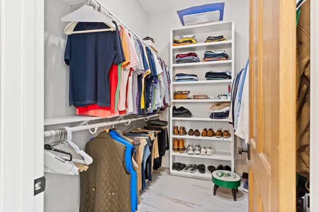 a view of a hallway with bathroom and wooden floor