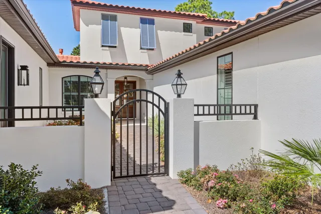 a view of a house with entryway and flower plants