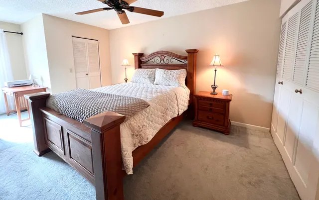 a spacious bedroom with a bed and a ceiling fan
