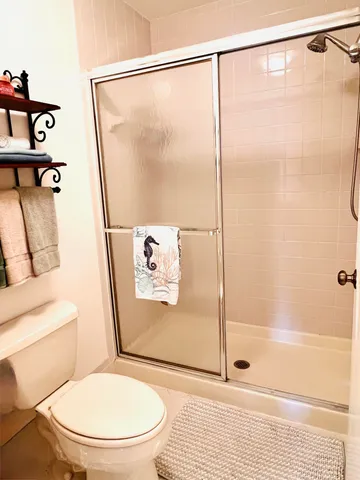 a bathroom with a toilet and a shower