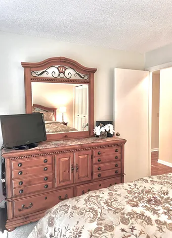 a view of a bedroom with a bed and mirror