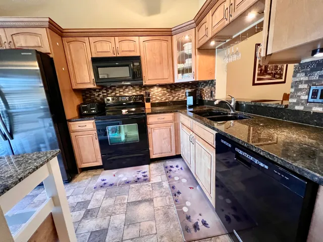 a kitchen with stainless steel appliances granite countertop a stove a sink and a microwave