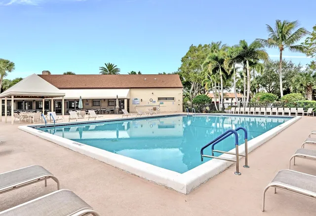 a view of swimming pool with outdoor seating and house in the background