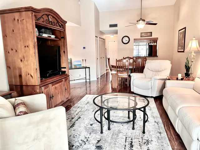 a living room with furniture a rug and a flat screen tv