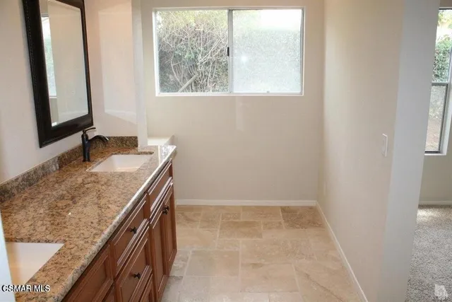 a bathroom with a granite countertop sink and a mirror