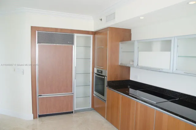 a kitchen with a refrigerator and a stove top oven