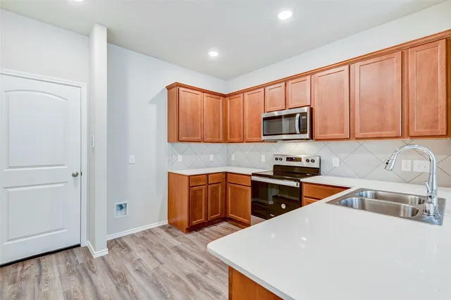 a kitchen with granite countertop a stove top oven a sink dishwasher and a microwave oven on granite countertops