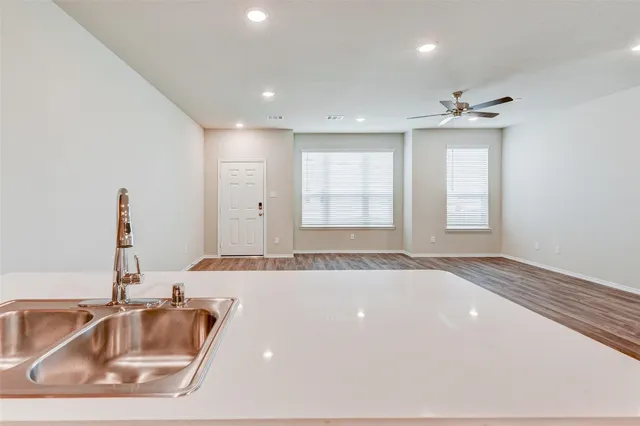 a view of a kitchen with a sink and dishwasher with wooden floor