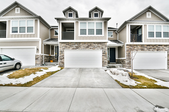 Three townhomes featuring stone veneer and horizontal siding exteriors
