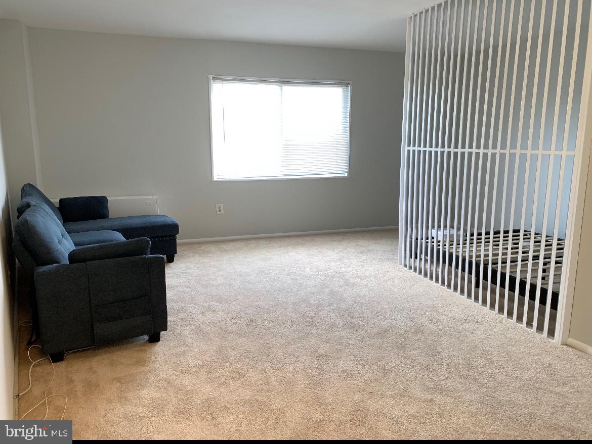 1111 University Boulevard West, Unit 501A Silver Spring, MD 20902 - Photo 3 of 11 a living room with furniture and a window