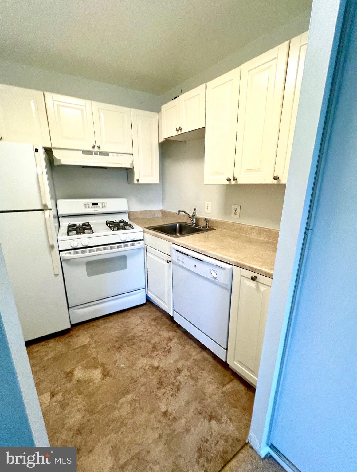 1111 University Boulevard West, Unit 501A Silver Spring, MD 20902 - Photo 6 of 11 a kitchen with a sink a stove a refrigerator and cabinets