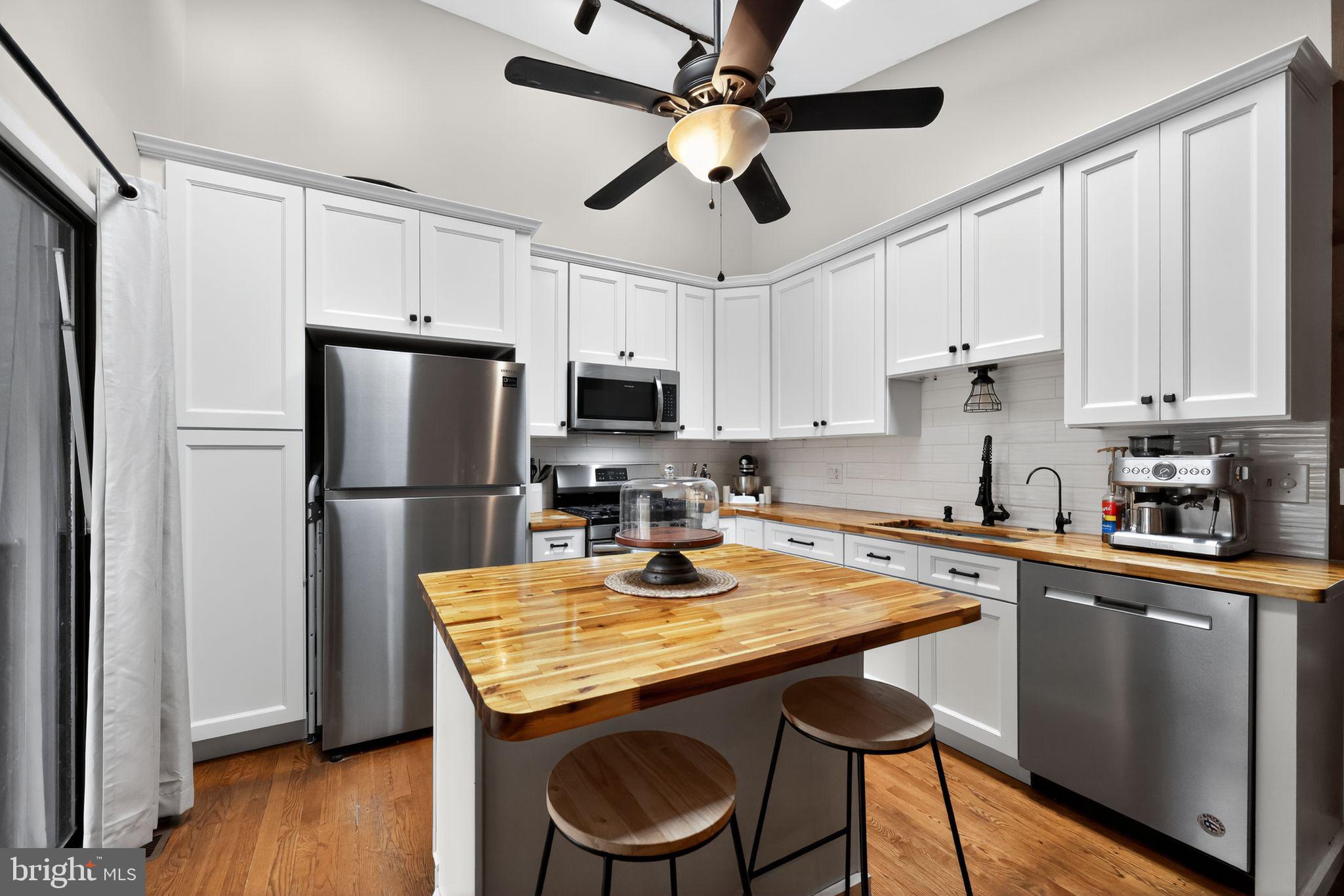 33 Beach Avenue Pennsville, NJ 08070 - Photo 11 of 32 a kitchen with stainless steel appliances granite countertop a dining table chairs refrigerator and microwave