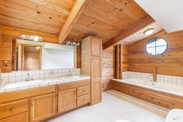 a spacious bathroom with a double vanity sink mirror and a bathtub