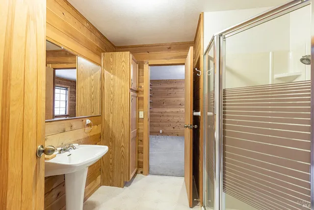 a bathroom with a sink a toilet a mirror and shower