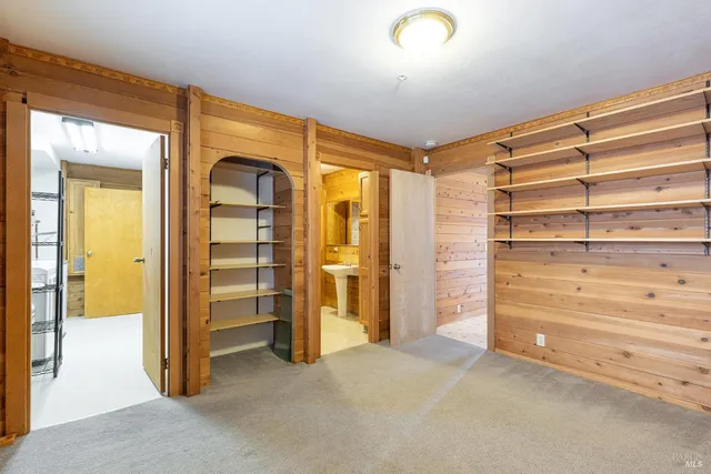 a view of walk in closet with clothes and shoes