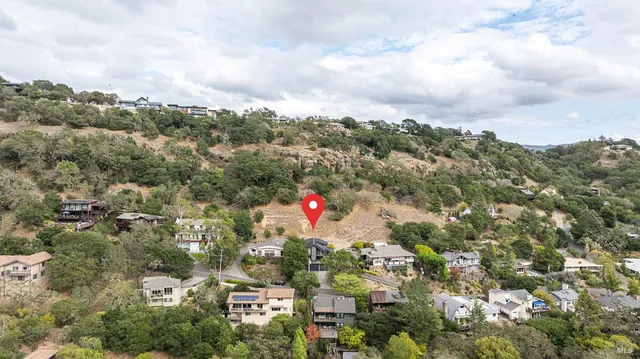 an aerial view of residential houses with city and green space