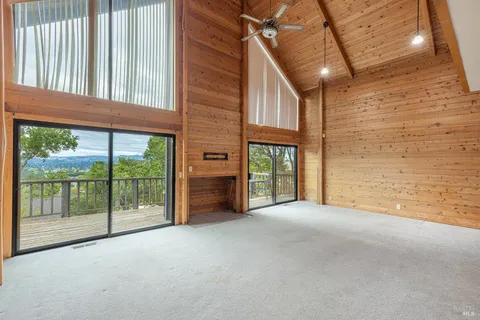 a view of an empty room with floor to ceiling windows