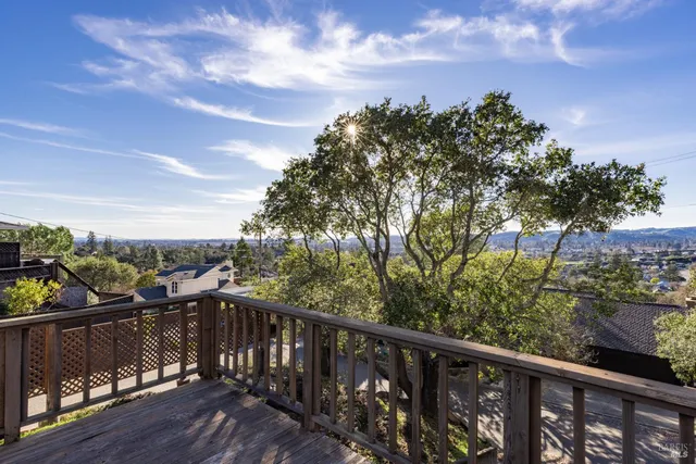 a balcony with wooden floor and city view