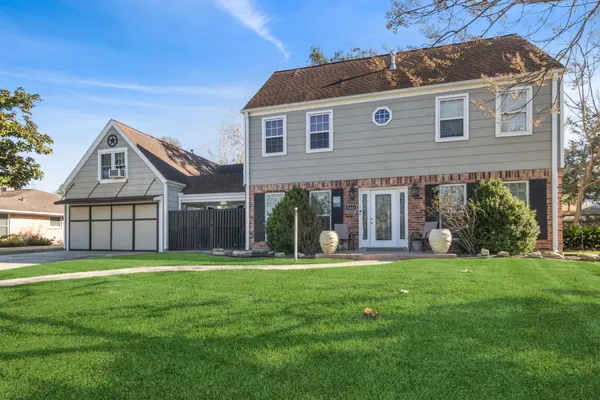 a view of a house with a big yard and sitting area