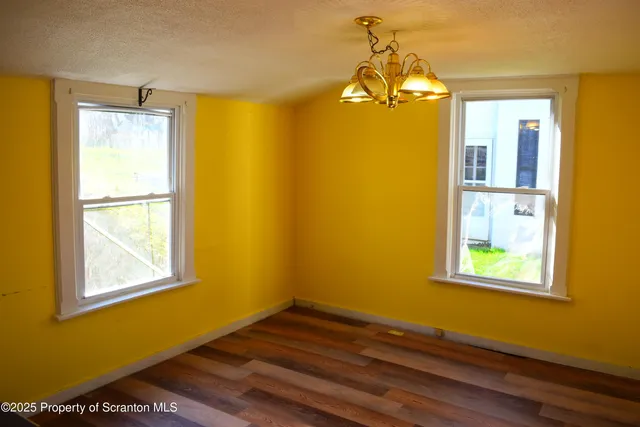 a view of a room with wooden floor and windows
