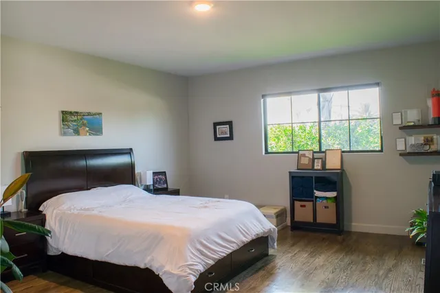 a view of swimming pool with lawn chairs plants and large trees