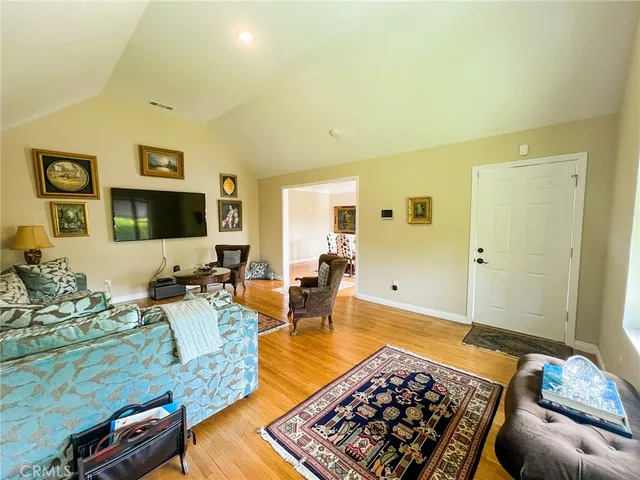 a living room with furniture a wooden floor and next to a window