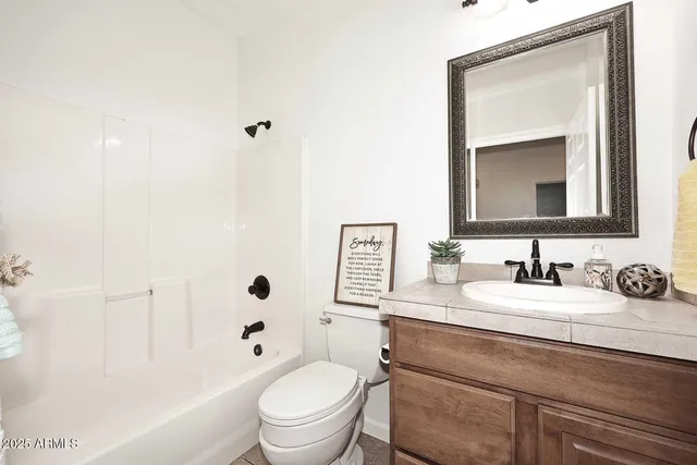 a bathroom with a toilet sink vanity tub and mirror