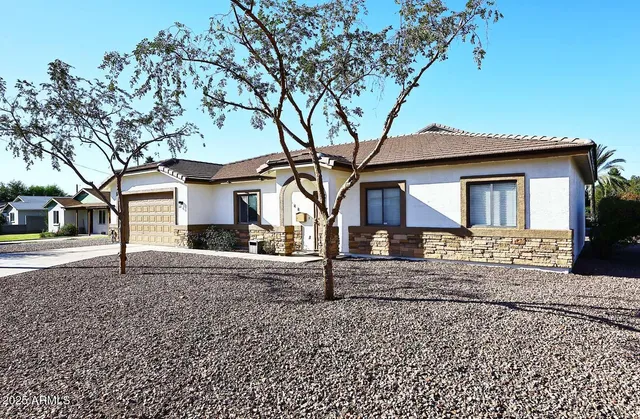 a front view of a house with a tree