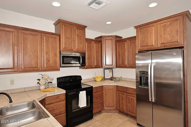 a kitchen with stainless steel appliances granite countertop a refrigerator a stove top oven a sink and dishwasher