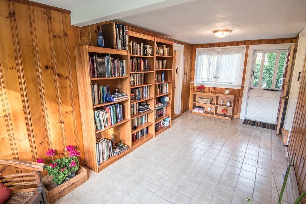 79 Park Street Dedham, MA 02026 - Photo 15 of 29 a hallway with a book shelf and a living room