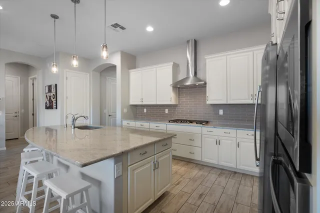 a kitchen with kitchen island a sink appliances and cabinets