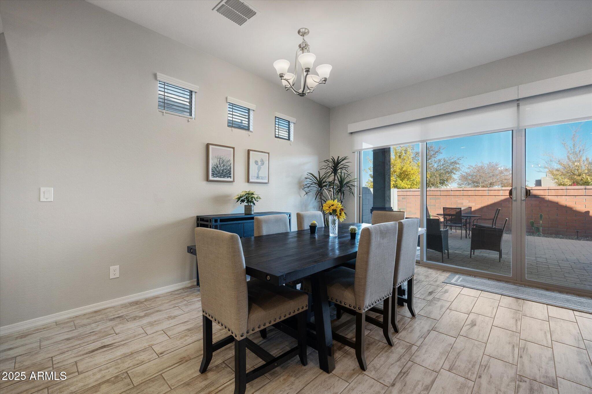 2527 South Quaintance Street Gilbert, AZ 85295 - Photo 8 of 36 a dining room with furniture a rug and a chandelier