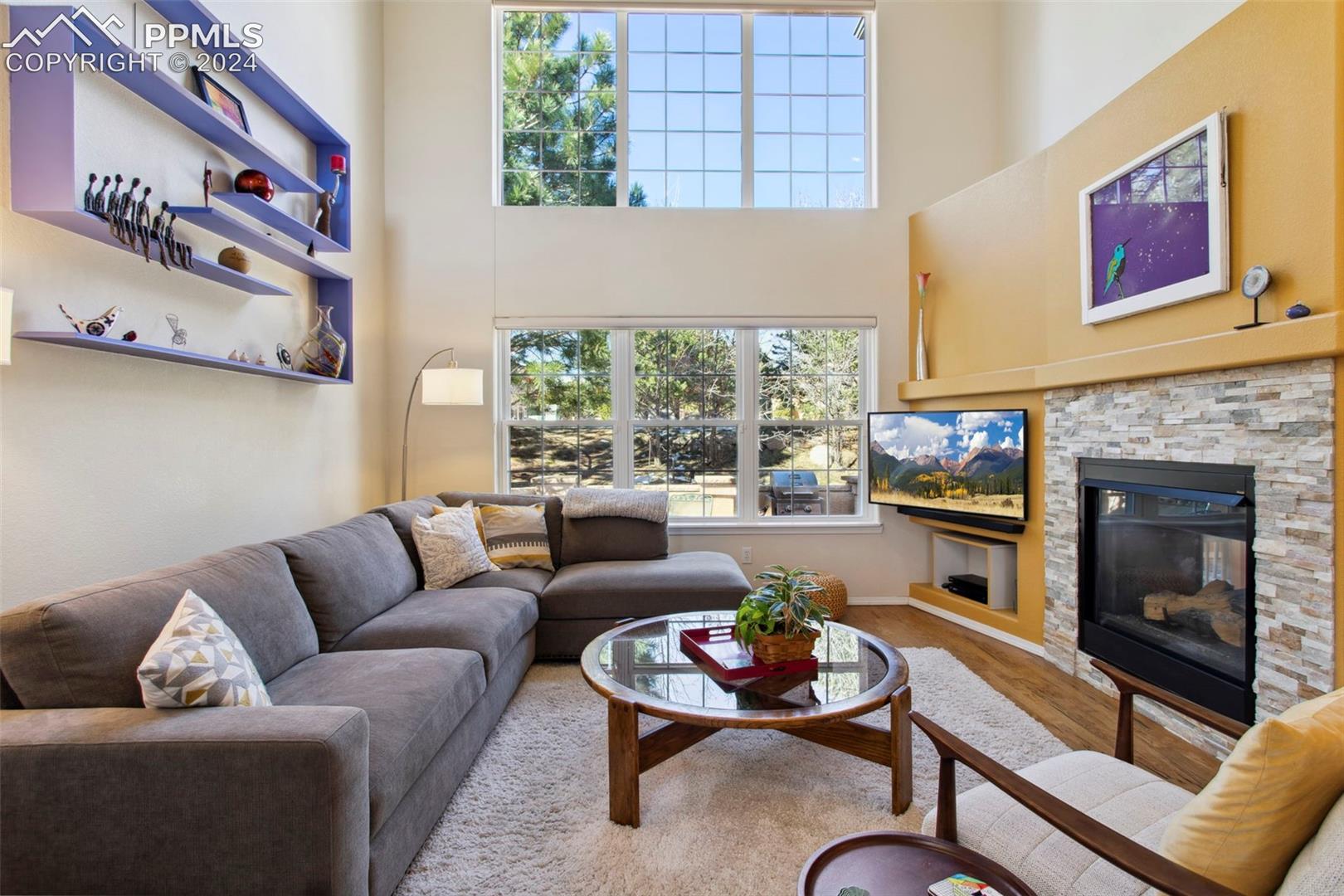 5655 Sonnet Ridge Point Colorado Springs, CO 80918 - Photo 7 of 47 Living room with a towering ceiling, wall of windows and two-sided gas fireplace
