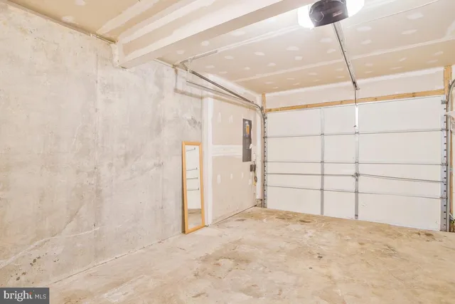 an empty room with wooden floor a fireplace and windows