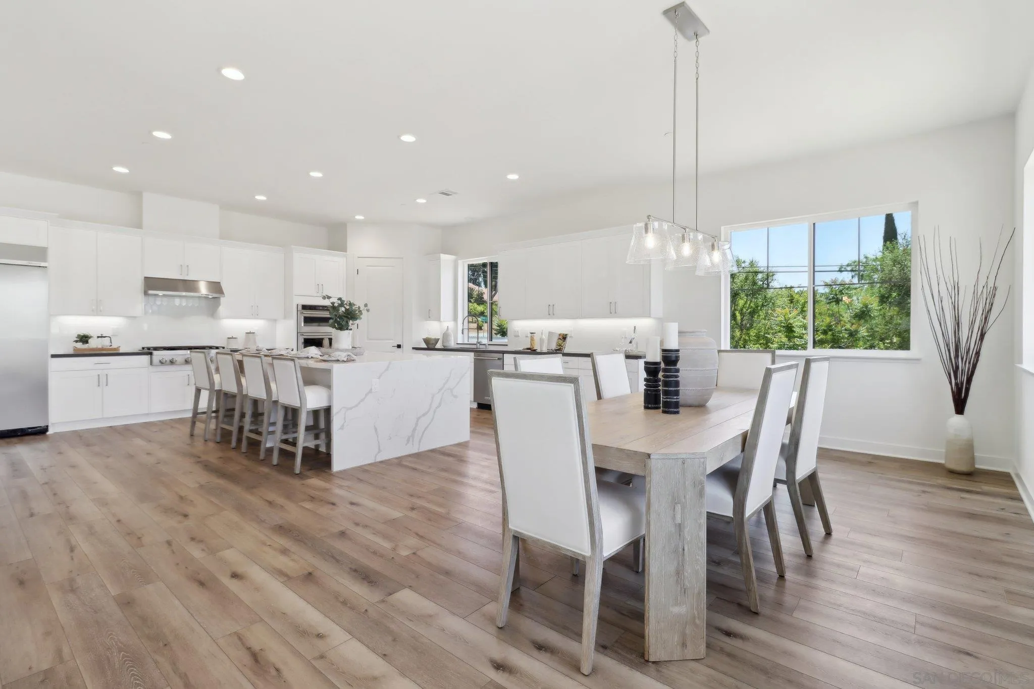 2745 Alexander Drive Escondido, CA 92029 - Photo 5 of 39 a kitchen with a dining table chairs wooden floor cabinets appliances and a window